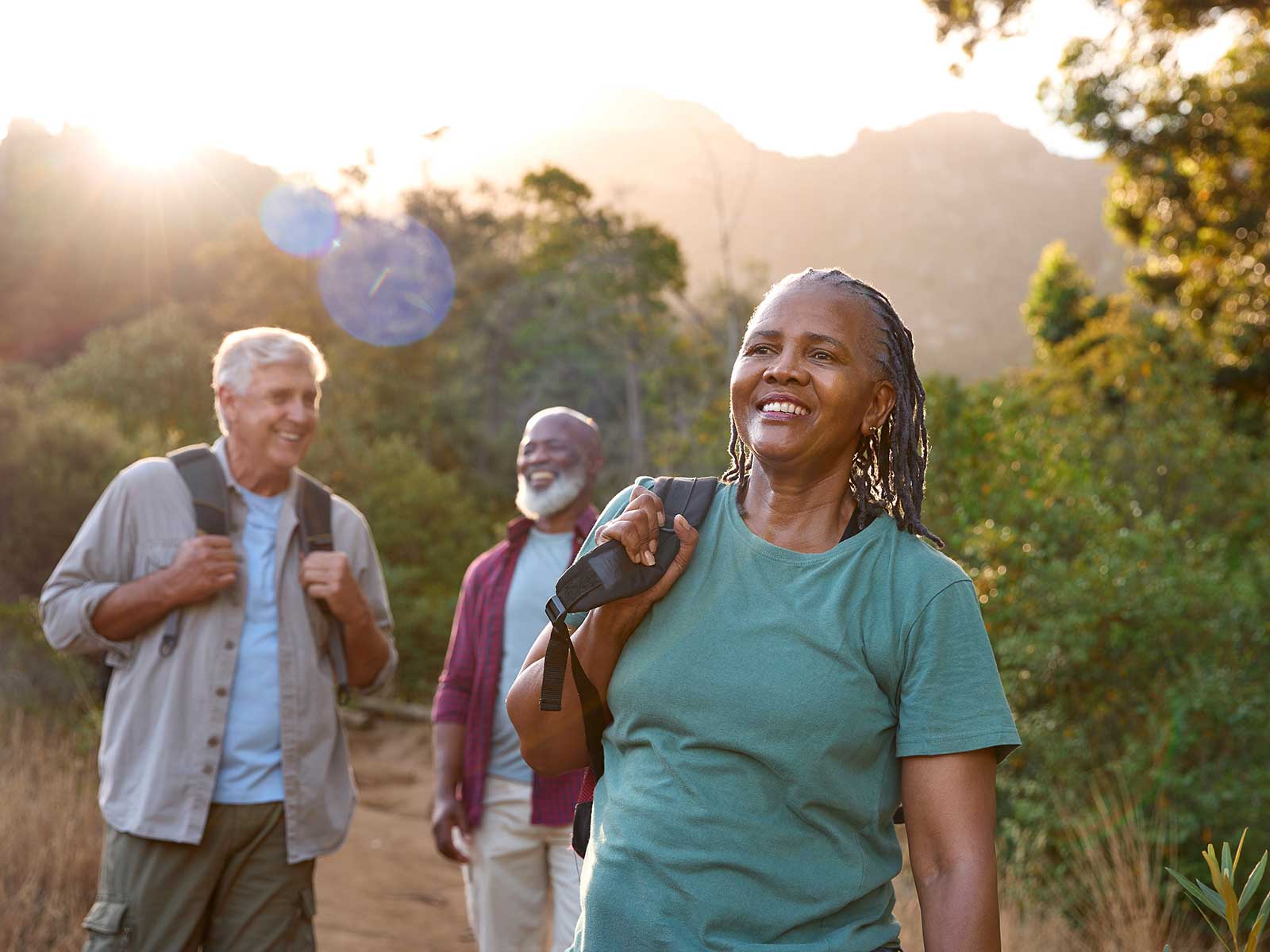 Three older adults hiking together in the mountains