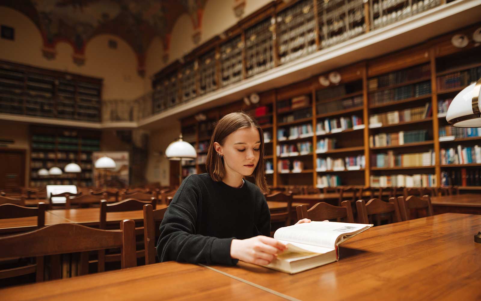 A student reading a book in a library